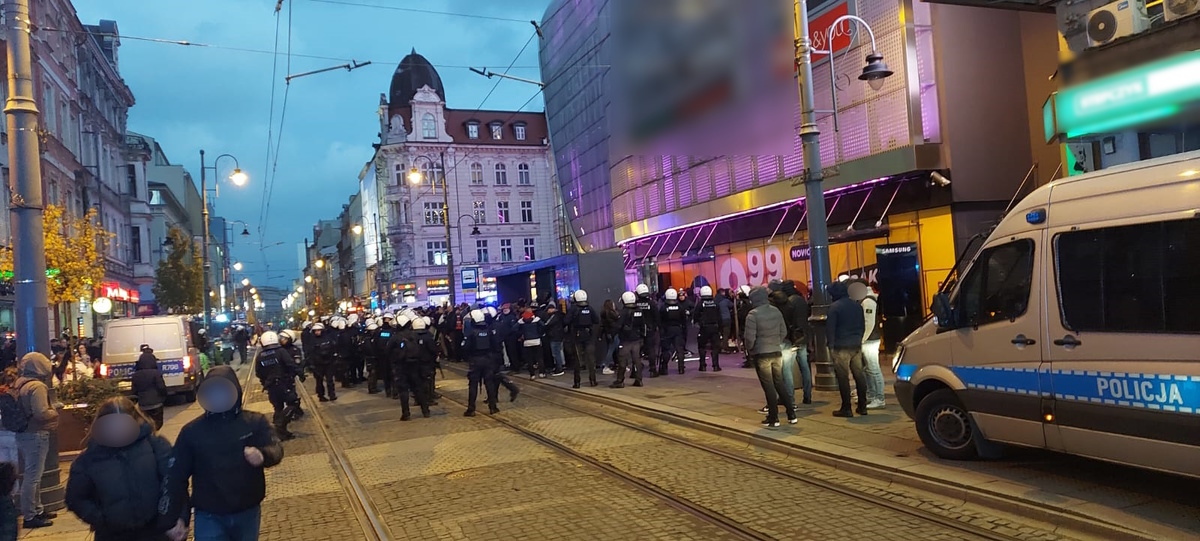 zdjęcie kolorowe: policjanci katowickiej komendy nadzorujący pseudokibiców Polonii Bytom w centrum miasta
