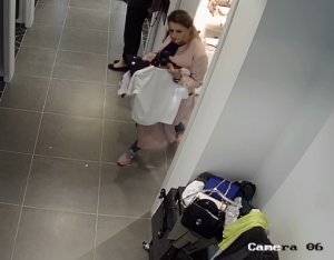 na zdjęciu widać sprawczynie kradzieży ubrań która jest w przymierzalni sklepu