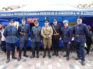 Na zdjęciu widać policjantów w mundurze Policji Państwowej II RP i Policji Województwa Śląskiego, który stoją obok stoiska
