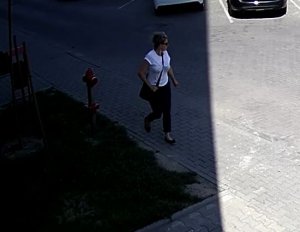 Na zdjęciu widać kobietę w białek koszulce i ciemnych spodniach która idzie po chodniku