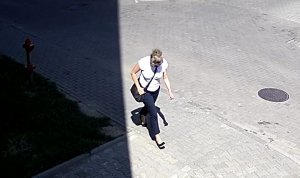 Na zdjęciu widać kobietę w białek koszulce i ciemnych spodniach która idzie po chodniku