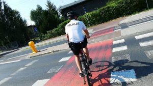 Na zdjęciu widać policjanta na rowerze, który jedzie przez przejazd dla rowerów w poprzek jezdni