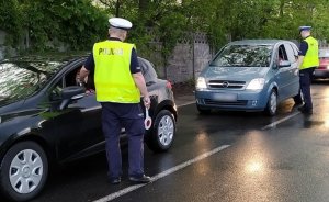 zdjęcie kolorowe: dwóch policjantów wydziału ruchu drogowego podczas kontroli trzeźwości kierujących pojazdami