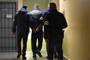 zdjęcie kolorowe: policjanci WPG KMP Katowice z mężczyzną podejrzanym o kierowanie zorganizowaną grupą przestępczą
