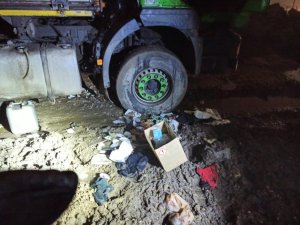 zdjęcie kolorowe: wyrzucone na ziemię skradzione rzeczy z pojazdu ciężarowego