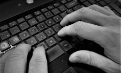 zdjęcie czarno-białe: męskie dłonie piszące na klawiaturze komputerowej