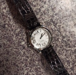 zdjęcie kolorowe: damski zegarek z białym cyferblatem i czarnym paskiem