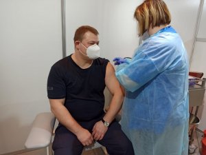 zdjęcie kolorowe: naczelnik wydziału sztab katowickiej komendy podczas szczepienia