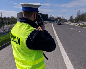 zdjęcie kolorowe: policjant katowickiej drogówki wykonujący pomiar prędkości pojazdu