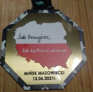zdjęcie kolorowe: jedna strona medalu przedstawiająca mapę konturową Polski i napis Jak trenujesz tak będziesz walczyć