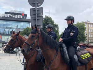 zdjęcie kolorowe: policjanci na koniach służbowych przed centrum handlowym SUPERSAM w Katowicach