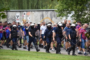 zdjęcie kolorowe: przemarsz pseudokibiców na stadion w asyście policjantów