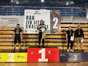zdjęcie kolorowe:  starszy posterunkowy Łukasz Banach na podium wraz z zawodnikami, którzy zajęli II i III miejsce