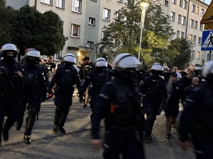 zdjęcie kolorowe: policjanci oddziału prewencji w asyście kroczącej prowadzą kibiców na katowicki stadion