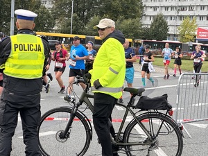 zdjęcie kolorowe: policjant drogówki na rondzie zabezpieczający trasę półmaratonu