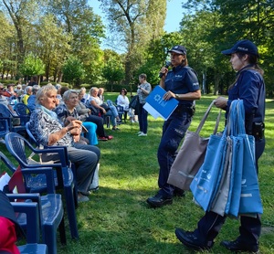 zdjęcie kolorowe: policjanci katowickiej komendy podczas rozmów z seniorami w parku podczas obchodów Dnia Seniora