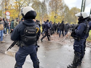 zdjęcie kolorowe: policjanci oddziału prewencji nadzorujący przemarsz pseudokibiców na stadion