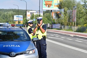 zdjęcie kolorowe: policjanci drogówki podczas kontroli prędkości pojazdów