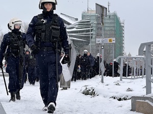 zdjęcie kolorowe: policjanci maszerujący z pseudokibicami w kierunku katowickiego Spodka
