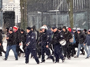 zdjęcie kolorowe: policjanci maszerujący z pseudokibicami na Placu Antala i Sławika