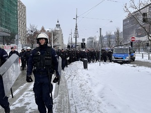 zdjęcie kolorowe: policjanci maszerujący z pseudokibicami w kierunku katowickiego Spodka