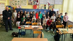 zdjęcie kolorowe: St. sierż. Mateusz Gęga i mł. asp. Bartłomiej Toboła podczas pamiątkowego zdjęcia z uczniami szkoły podstawowej nr 5 w Katowicach