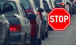 zdjęcie kolorowe:samochody stojące w korku i znak STOP
