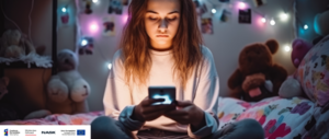zdjęcie kolorowe: nastolatka siedząca na łóżku która korzysta z telefonu komórkowego