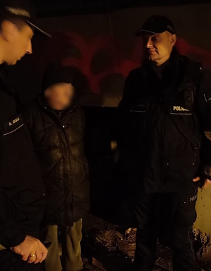 zdjęcie kolorowe: dwóch policjantów rozmawiających z mężczyzną dotkniętym problemem bezdomności